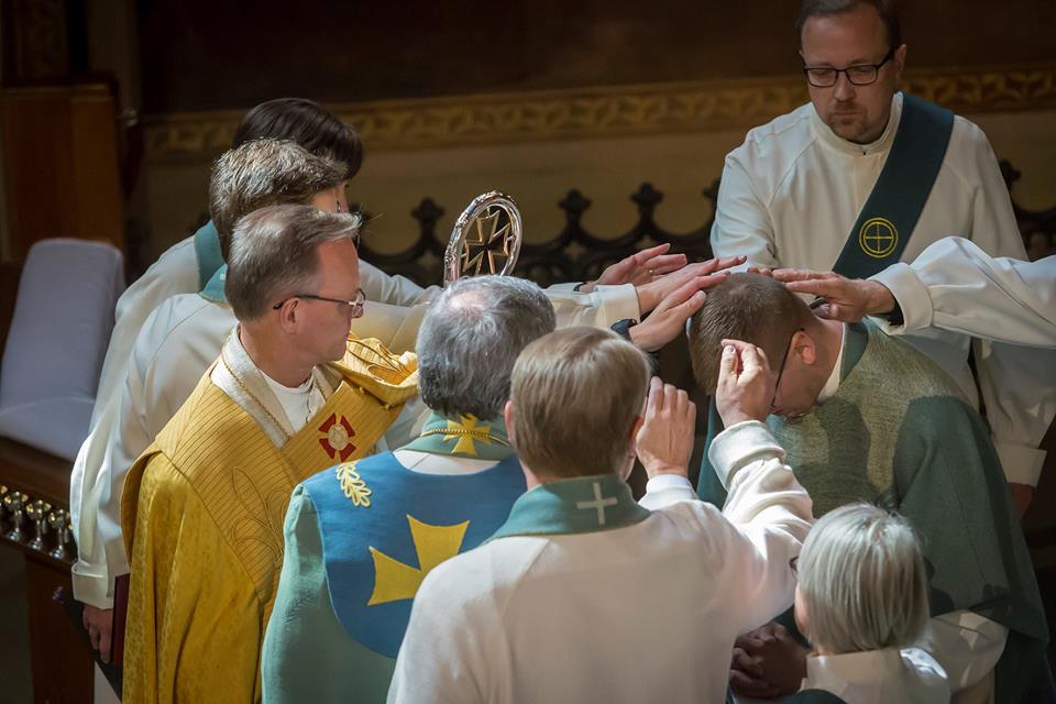 Kädet laskettu papiksi vihittävän henkilön päälle.